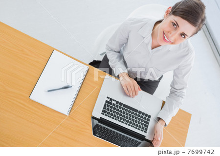 Pretty businesswoman smiling up at camera Pretty businesswoman smiling up at camera 7699742