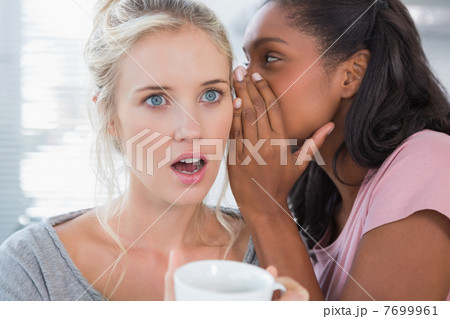 Young woman whispering secret to her friend Young woman whispering secret to her friend 7699961