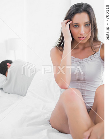 Woman feeling worried sitting in bed 7700118