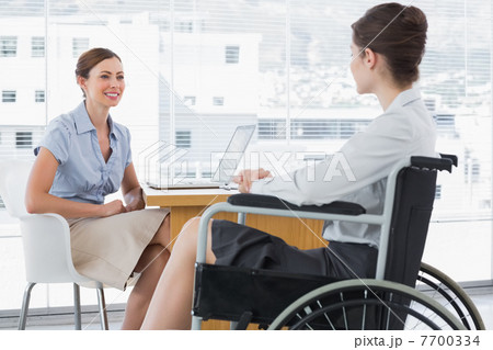 Businesswoman speaking with disabled colleague Businesswoman speaking with disabled colleague 7700334
