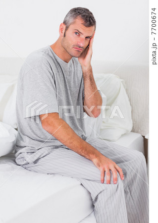 Worried man sitting in bed 7700674