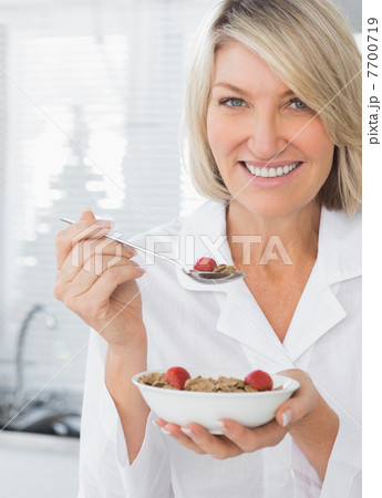Smiling woman having cereal for breakfast 7700719