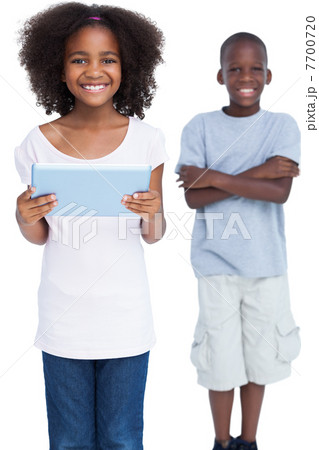 Smiling girl holding tablet pc with her brother Smiling girl holding tablet pc with her brother 7700720