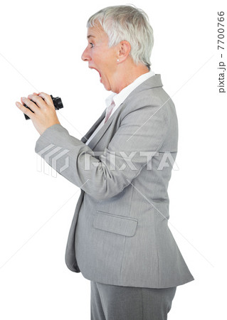 Surprised businesswoman holding binoculars Surprised businesswoman holding binoculars 7700766