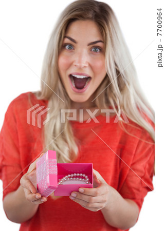 Surprised woman discovering necklace on a box 7700964
