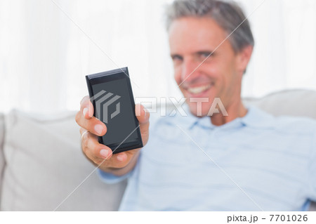 Man showing smartphone to camera 7701026