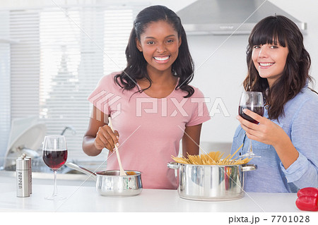 Happy friends preparing dinner together 7701028