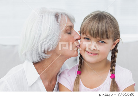 Grandmother kissing her cute granddaughter 7701030