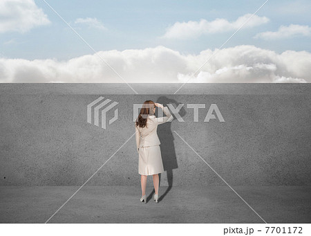Businesswoman watching a grey wall 7701172