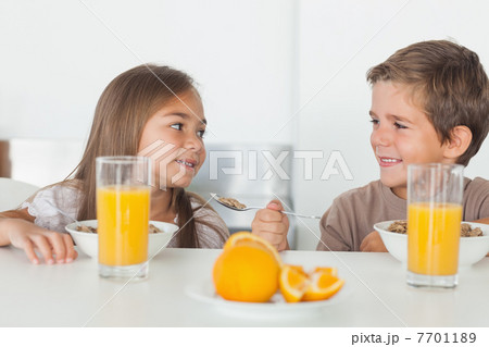 Siblings looking at each other during breakfast 7701189