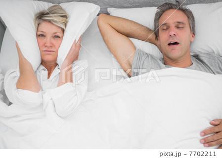 Man snoring loudly as partner blocks her ears 7702211