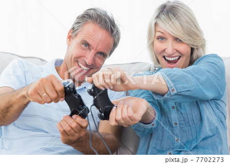 Couple playing video games on the couch 7702273