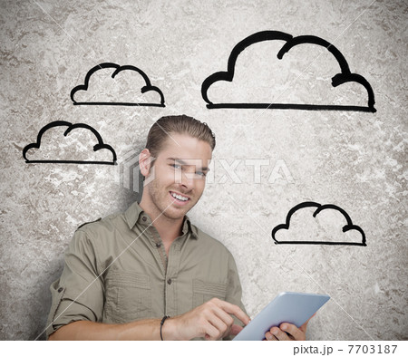 Smiling man using a tablet computer 7703187