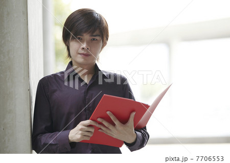 Asian Business man holding a folder Asian Business man holding a folder 7706553