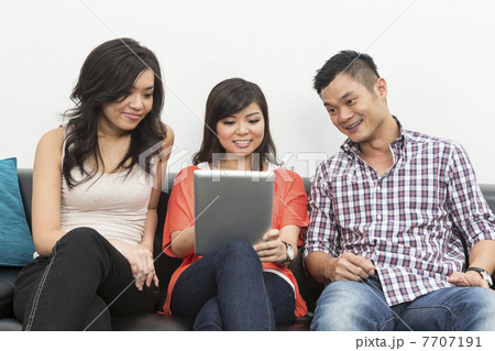 Chinese friends hanging out together using Digital Tablet 7707191