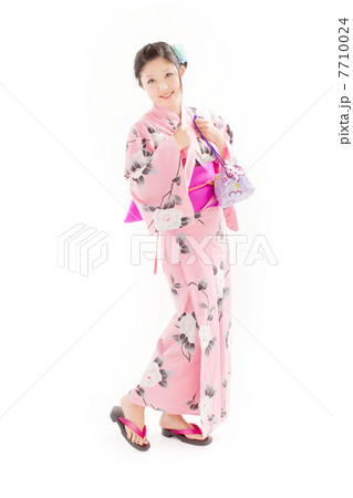 お洒落なピンクの浴衣で可愛らしいポーズをする黒髪の女性の写真素材