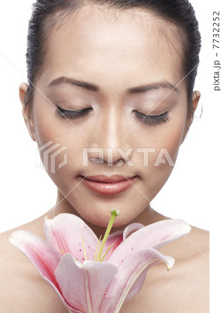 Close-up of a young Asian woman holding a lily Close-up of a young Asian woman holding a lily 7732252
