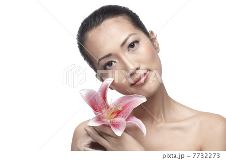 Close-up of a young Asian woman holding a lily 7732273