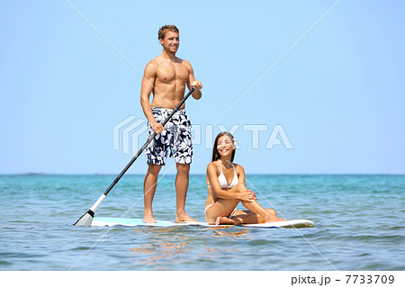 Beach fun couple on stand up paddleboard 7733709