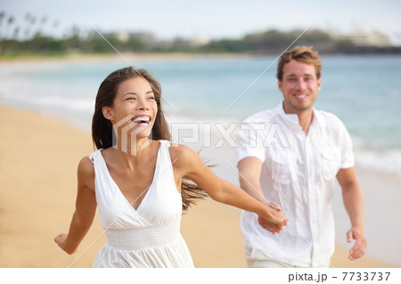 Beach couple running having fun laughing together 7733737