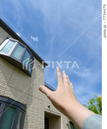 青空に向かって手を伸ばす住宅の外観 7734479