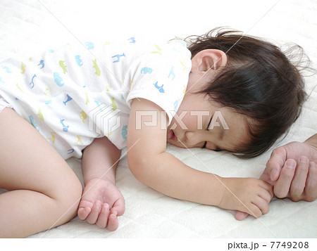 父の指を掴み昼寝をしている子供 7749208