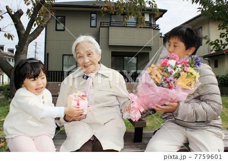 かわいい孫たちにプレゼントをもらうおばあちゃん かわいい孫たちにプレゼントをもらうおばあちゃん 7759601
