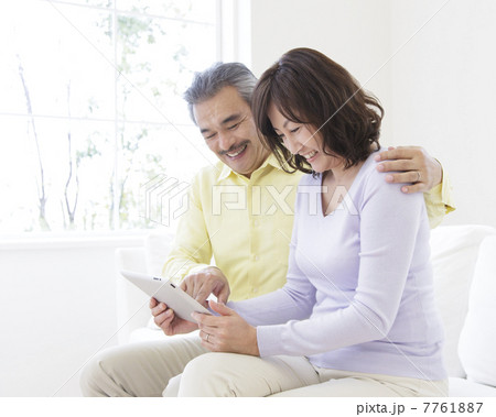 タブレットPCを見る中高年夫婦 7761887