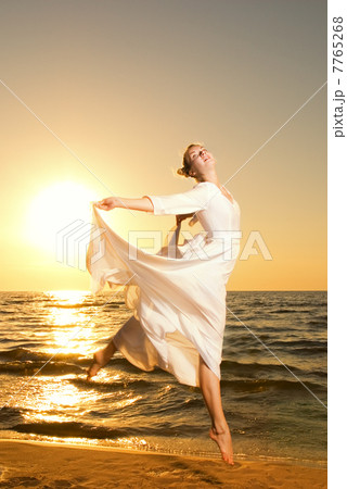 Beautiful young woman jumping on a beach at sunset Beautiful young woman jumping on a beach at sunset 7765268