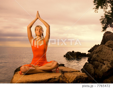 Beautiful young woman doing yoga exercise outdoors 7765472