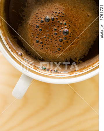 Cup of dark brown coffee on a wooden table 7765725
