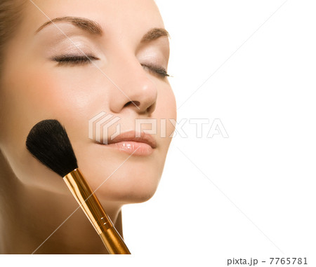Beautiful young woman with a make-up brush. Isolated on white ba Beautiful young woman with a make-up brush. Isolated on white ba 7765781