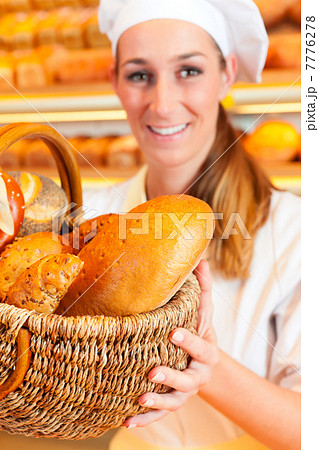 Female baker selling bread by basket in bakery 7776278
