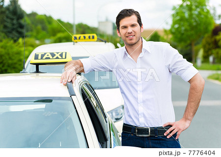 Driver in front of taxi waiting for clients 7776404