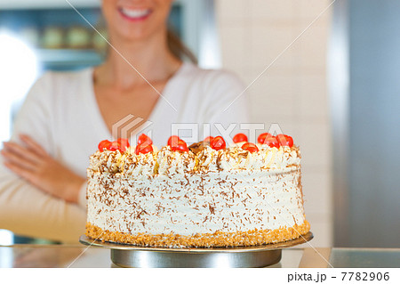 Female baker or pastry chef with torte 7782906
