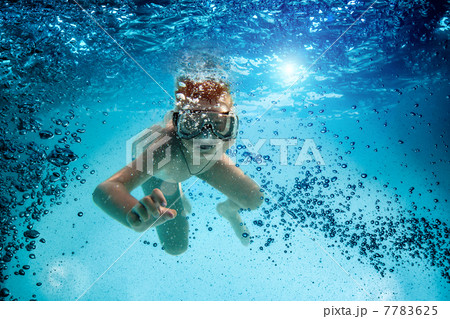 Teenager in the mask and snorkel swim underwater. 7783625