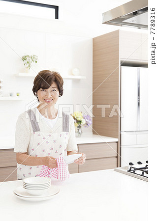 キッチンでお皿を拭く女性 7789316