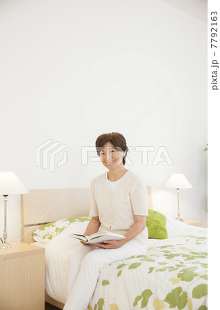 ベッドルームで読書する女性 7792163