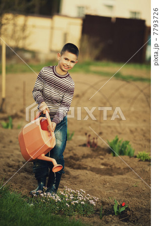 little helper watering flowers in the garden 7793726