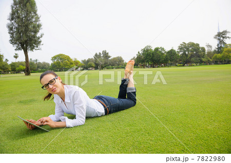 Beautiful young woman with tablet in park 7822980