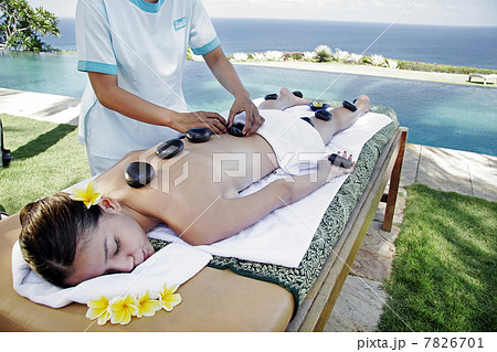 Womon lying on massage table outdoors 7826701