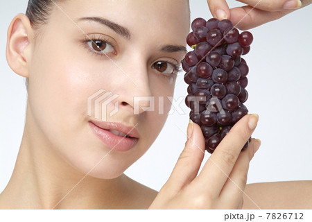 Close-up of young woman holding grapes Close-up of young woman holding grapes 7826712