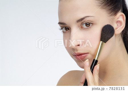 Woman applying blush to her cheek 7828131