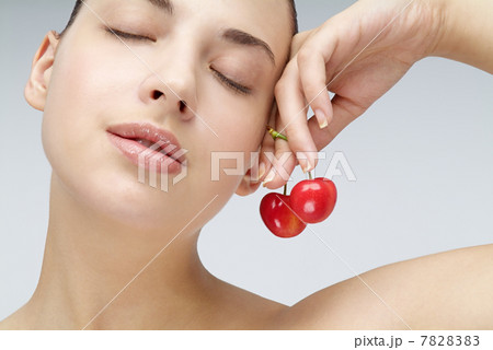 Close-up of young woman holding cherry Close-up of young woman holding cherry 7828383
