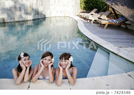 Three young women standing in swimming pool 7828386