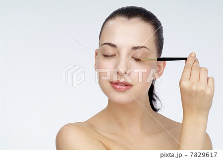"Young woman brushing eyebrows,close-up" 7829617