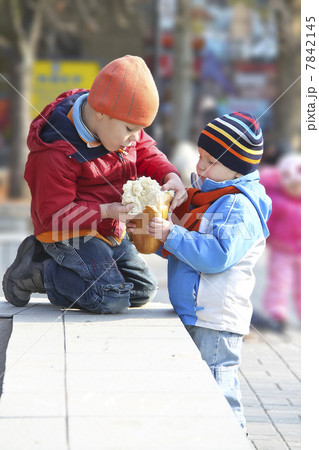 The brothers share the bread for a walk in autumn park The brothers share the bread for a walk in autumn park 7842145