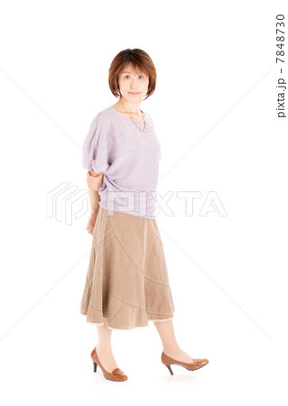 春夏ファッションで歩くポーズをする40代の女性 7848730