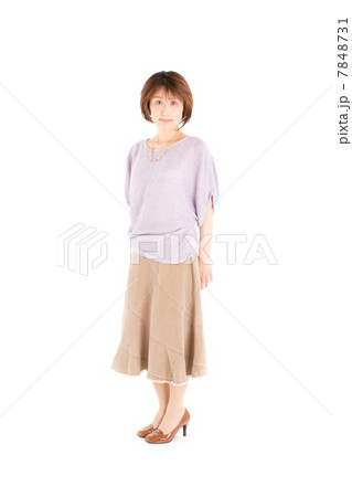 お洒落な春夏ファッションでポーズをとるミドルの綺麗な女性の写真素材