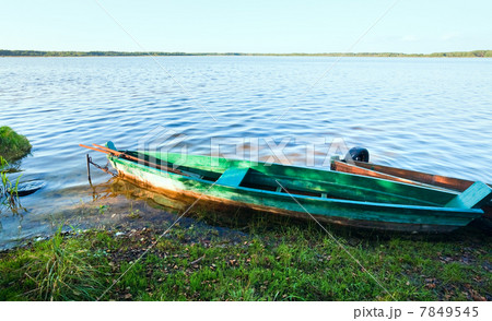 Boat near the summer lake shore Boat near the summer lake shore 7849545